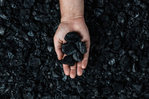 Male,Hand,With,Coal,On,The,Background,Of,A,Heap